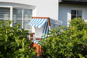 ヴェニングシュテットにあるHaus Heideresidenz App 24の家の前に座る青白の椅子