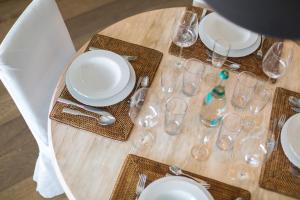 einen Tisch mit Tellern und Gläsern auf einem Holztisch in der Unterkunft Villa Bellevue in Wenningstedt-Braderup