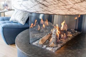 a fire in a fireplace in a living room at Hafen27List - Meeresrauschen - Haus 4 in List
