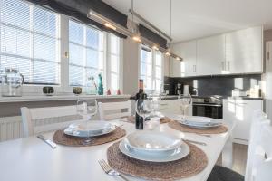 uma cozinha com uma mesa com pratos e copos de vinho em Windlicht em Munkmarsch