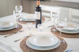 a table with white plates and wine glasses on it at Windlicht in Munkmarsch