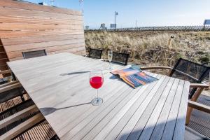 a wooden table with a glass of wine on a deck at Hafen27List - Meeresrauschen - Haus 4 in List +47 photos