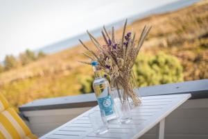 a bottle on a table with a bouquet of flowers at Wattblick in Munkmarsch