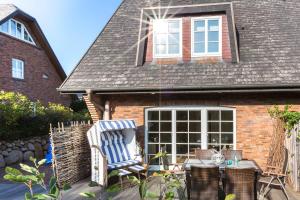 a patio with two chairs and a house at Heide Hues in Munkmarsch