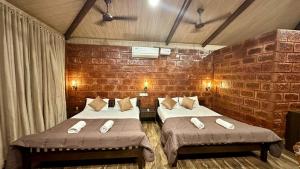 KashidにあるThe Beach Hive Resortのレンガの壁、ベッド2台が備わる客室です。