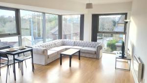 sala de estar con sofá, mesas y ventanas en Homestay by BIC Melbourne 14 - LEEDS en Morley