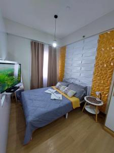 a bedroom with a bed and a flat screen tv at Sojourn at SMDC Hope Residences in Trece Martires +20 photos