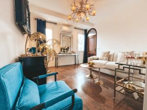 a living room with a blue couch and a chandelier at LE MURANO LUXURY LAGOON in Murano