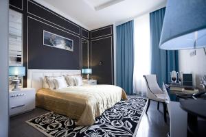 Mirax Boutique Hotel في خاركوف: غرفة نوم بسرير ومكتب وكرسي