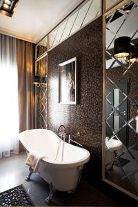 a bathroom with a tub and a tile wall at Mirax Boutique Hotel in Kharkiv