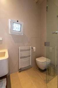 a bathroom with a toilet and a window at La Chapelle Est in Agios Romanos