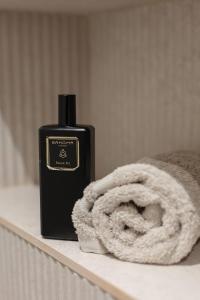 a bottle of soap on a shelf next to a towel at Maison Lùisa - Refuge d'Exception au cœur d'Autun in Autun +60 photos