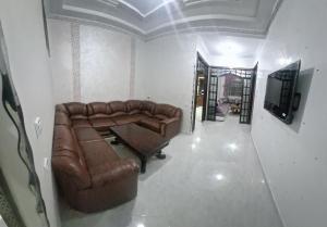 un salon avec un canapé en cuir et une table dans l'établissement Résidence MIMOUNA FAMILY, à Tanger