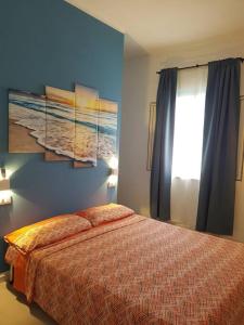 una camera da letto con un letto e una parete blu di Casa Vacanza Villa Stefy - Salento a Torre Chianca