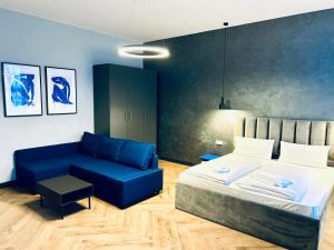 1 dormitorio con 1 cama y 1 sofá azul en Motel Blue Messe, en Berlín