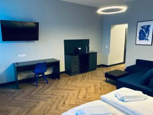 een slaapkamer met een bureau en een bed en een bureau met een computer bij Motel Blue Messe in Berlijn