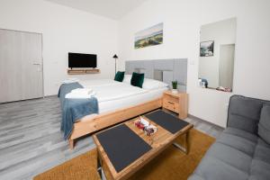 a bedroom with a large bed and a couch at Penzion MOVEINN in Prague