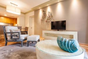 Pine Cliffs Suites في ألبوفيرا: غرفة معيشة مع أريكة وتلفزيون