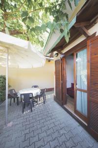 a patio with a table and chairs and an umbrella at Heliopolis Camping & Village in Pineto