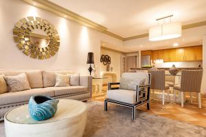 Pine Cliffs Suites في ألبوفيرا: غرفة معيشة مع أريكة وطاولة