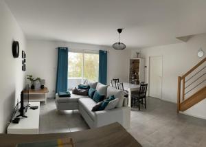 a living room with a couch and a table at Les Villas de Castel - villa "Les Muriers" in Castelmaurou