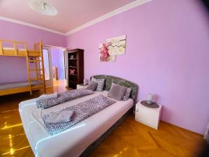 Sala de estar con cama y pared púrpura en Mo relax vendégház, en Mórahalom