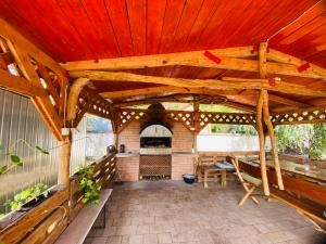 um pátio exterior com uma pérgola de madeira em Mo relax vendégház em Mórahalom
