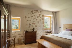 a bedroom with a bed and two windows at El Priorato de Trespaderne in Trespaderne +49 photos