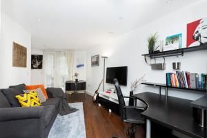 uma sala de estar com um sofá e uma mesa em Bright & Cozy 1 BDR Apt wCharming Private Terrace em Londres