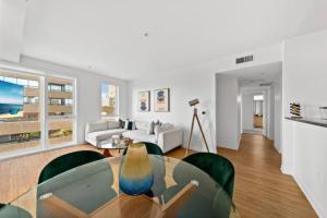 a living room with a glass table and chairs at Downtown Santa Monica Top Floor Ocean View 2BR/2BA in Los Angeles