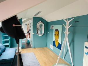 ein Wohnzimmer mit einem Gemälde eines Mannes an der Wand in der Unterkunft B&B Huize Van Damme in Nieuwpoort