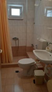 y baño con aseo y lavamanos. en Villa Metaxa, en Paralia Katerinis