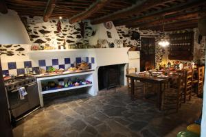 a kitchen with a table and a stove and a fireplace at Cortijo rural El Albercón - Capileira - Alpujarra Rural in Capileira