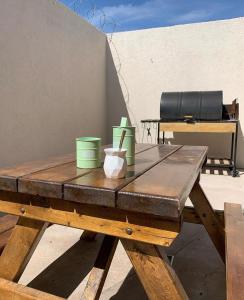 una mesa de picnic de madera con contenedores verdes. en La vecindad San Rafael en San Rafael