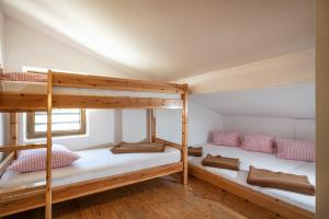 two bunk beds in a room with wooden floors at Berggasthof Rofan in Maurach