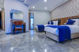 une chambre d'hôtel avec deux lits et un bureau dans l'établissement Silver Inn Spa, à Kasaplar