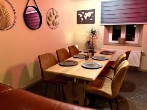 uma mesa de jantar com cadeiras e pratos em Chez Koulla et Romu em Durbuy