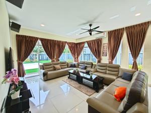 uma ampla sala de estar com sofás e uma ventoinha de tecto em Marinea 2, The Inspaze by Antlerzone em Kota Tinggi