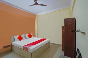 1 dormitorio con 1 cama y ventilador de techo en OYO Flagship Mohan Residency, en Indirapuram