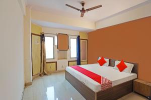 a bedroom with a bed with red pillows on it at OYO Flagship Mohan Residency in Indirapuram