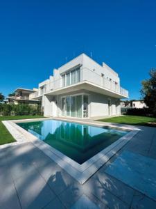 een huis met een zwembad ervoor bij Stunning villa with pool and lagoon view in Palazzo Vianello