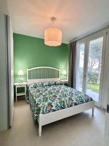 een slaapkamer met een bed en een groene muur bij Stunning villa with pool and lagoon view in Palazzo Vianello