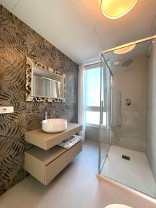 een badkamer met een wastafel en een spiegel aan een muur bij Stunning villa with pool and lagoon view in Palazzo Vianello