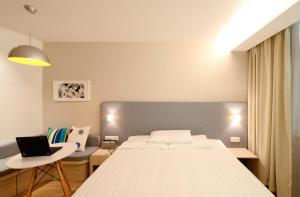 a bedroom with a bed and a laptop on a table at GRANDE CHAMBRE dans charmante maison alsacienne in Herrlisheim
