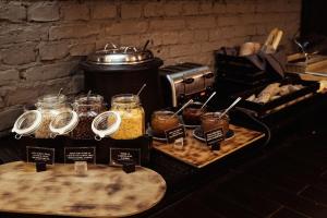 a buffet with jars of food and a slow cooker at Konventa Sēta Hotel - Keystone Collection in Riga