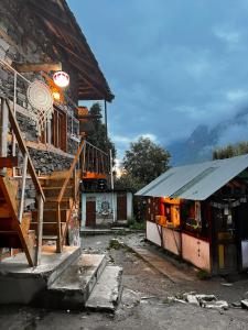 a building with a basketball hoop next to a house at Old Brahma Homestay in Kalgha