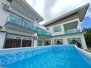 uma casa com uma piscina em frente em Marinea 2, The Inspaze by Antlerzone em Kota Tinggi