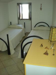 タヴィアーノにあるCasa Bella Vistaのベッド2台、テーブル、窓が備わる客室です。