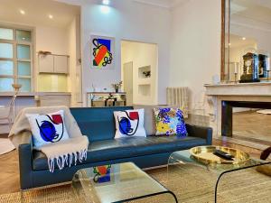 ein Wohnzimmer mit einem blauen Sofa und einem Kamin in der Unterkunft L'empereur - Parking - Fibre - Netflix in Montauban