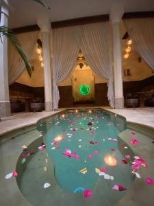uma piscina de água com flores no chão em Dar Alif em Marraquexe